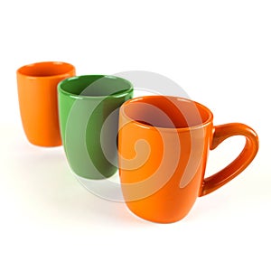 Row of Seasonal Coffee Mugs in Orange and Green on White Background