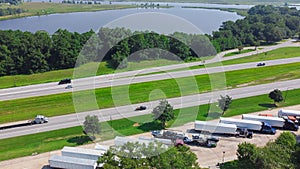 Row of semi-trucks, containers, cargo trailers parking lot Jackson County Rest Area West along Highway Intestate