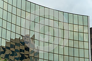 Row of shimmering glass pannels on side of modern office building in downtown city in urban business districts