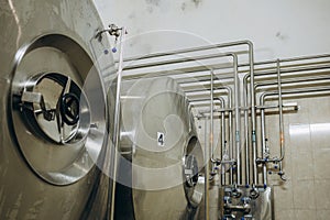 Row of shiny metal micro brewery tanks. Beer factory