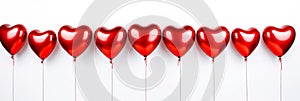A row of shiny red heart-shaped balloons isolated on white background. Valentine’s Day concept with glossy heart