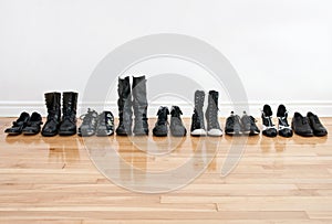 Row of shoes and boots on a wooden floor