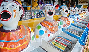 A row of sideshow carnival game clowns with mouths open diminish