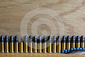 A row of small caliber bullets and one empty cartridge