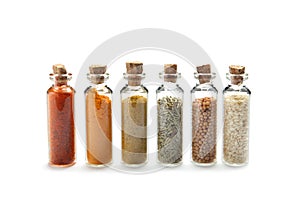 Row of small glass bottles with different spices