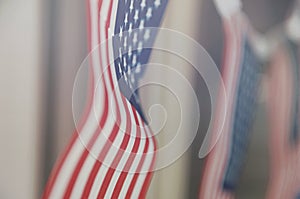 Row of small identical American flags, decorative for themes of summer, pride, Americana, USA flag concept.