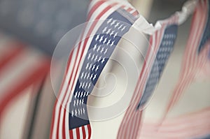 Row of small identical American flags, decorative for themes of summer, pride, Americana, USA flag concept.