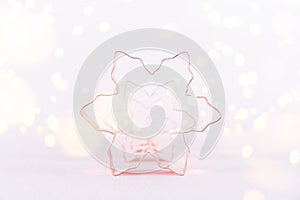 Row of Snowflake Copper cookie cutters on white sparkling background with bokeh lights. Holiday Christmas and New Year
