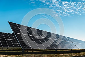 row of solar panels under blue sky, in new solar photovoltaic plant