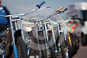 Row of speedway motorbikes outside in the sun