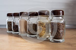 Row of spice jars containing various herbs and spices