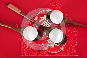 A row of spoons with dumplings on the red envelope