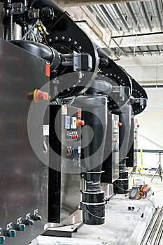 A row of steam boilers and blower fans in a heating system.