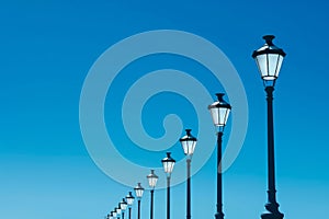 Row of Street Lamps Against a Clear Blue Sky. Generative ai