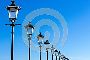 Row of Street Lamps Against a Clear Blue Sky. Generative ai