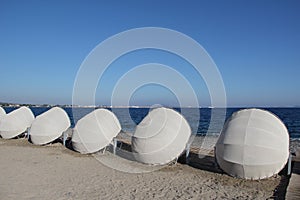 Row of sun beds with white dome covers on a beach at Kos Island in Greece