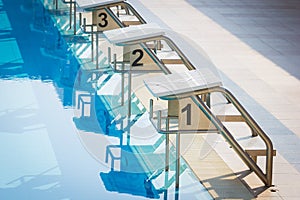 A Row Of Swimming Pool Starting Blocks At The pool Edge. Horizon