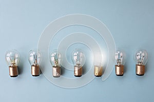 Row of switched off light bulbs with one switched on.