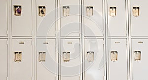 A row of tan lockers in a hallway of a school.