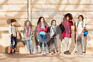 Row of teenagers with skateboards and rollerblades