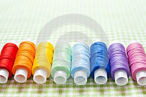 Row of thread spools in rainbow colors
