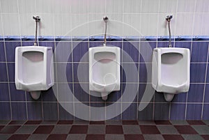 Row of three Urinals low light