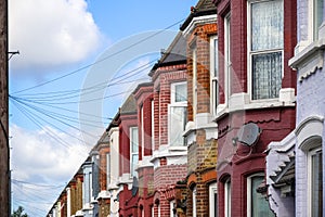 A row of typical British terraced houses in London with overhead cable lines