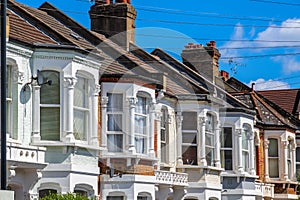 A row of typical British terraced houses in London with overhead cable lines