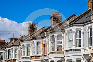 A row of typical British terraced houses in London with overhead cable lines