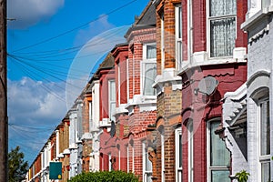 A row of typical British terraced houses in London with overhead cable lines