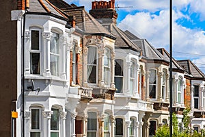 A row of typical English terraced houses in London with overhead cable lines