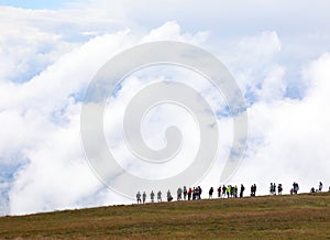 row of unrecognizable people looking towards the horizon