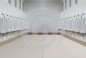 A row of urinals in tiled wall in a public restroom.