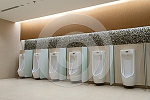 A row of urinals in tiled wall in a public restroom. Empty man toilet