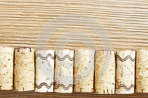 A row of used wine corks on a old wooden table. Top view.