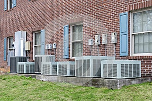 Row of Various Air Conditioners Outside multiple Businesses in a Strip Center