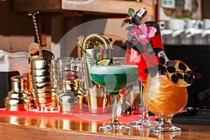 Row of various colourfull alcoholic cocktails on on the bar counter. Glasses of differen shapes. Cocktail card. Bar menu.