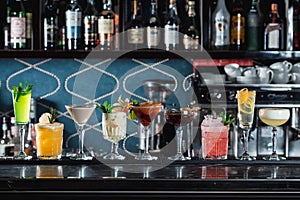 Row of various colourfull alcoholic cocktails on a bar desk. Glasses of differen shapes