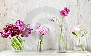 A row of vases with pink flowers