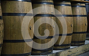 A row of vertical hooped wooden barrels photo
