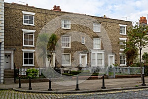 A row of Victorian terraced houses in old commercial road in Portsmouth with cobbled streets, the street that Charles Dickens was