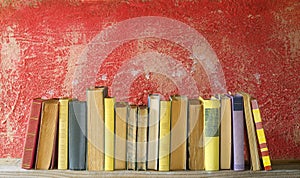 Row of vintage books on red background