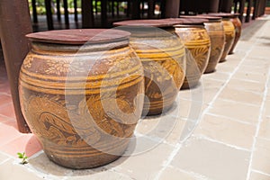 Row of water jar with dragon pattern and wooden lid