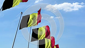 Row of waving flags of Belgium agaist blue sky, 3D rendering