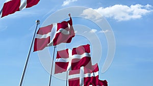 Row of waving flags of Denmark agaist blue sky, 3D rendering