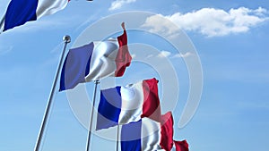 Row of waving flags of France agaist blue sky, 3D rendering