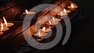 Row of Wax Prayer Candles Lit on Stand in Christian Catholic Church