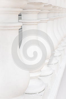 Row of white columns, close-up. Balustrades, balusters. Building is decorated in classic style. Details of architecture.