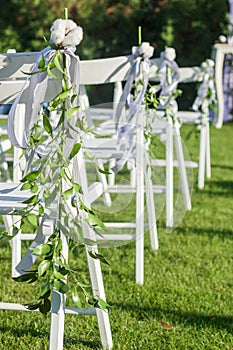 Row of white folding chairs before a wedding ceremony. Vertical orientation