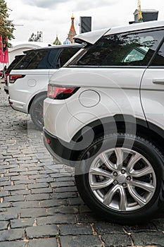 A row of white jeeps stands on the red square in Moscow